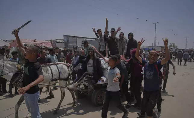 Palestinians carry bags containing food and humanitarian aid packages delivered by the Gaza Humanitarian Foundation, a U.S.-backed organization, in Rafah, southern Gaza Strip, Sunday, June 8, 2025. (AP Photo/Abdel Kareem Hana)
