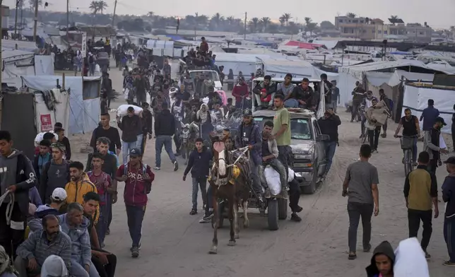 Palestinians carry bags filled with food and humanitarian aid provided by the Gaza Humanitarian Foundation, a U.S.-backed organization approved by Israel, in Khan Younis, southern Gaza Strip, on Tuesday, June 3, 2025. (AP Photo/Abdel Kareem Hana)