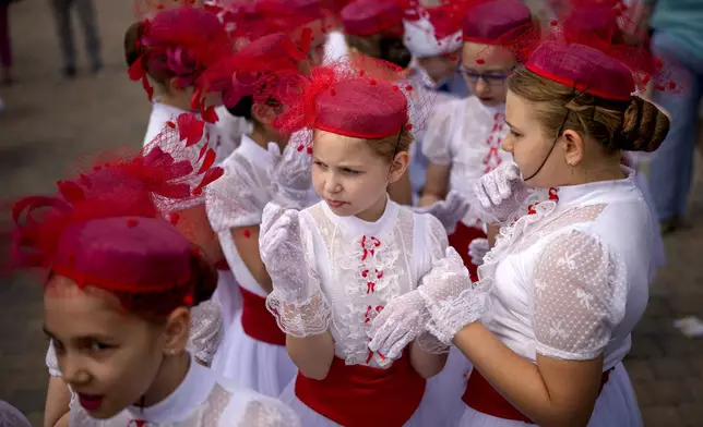 Students of a dance school wait outside Romania's Palace of Parliament during a series of events marking International Children's Day in Bucharest, Romania, Sunday, June 1, 2025. (AP Photo/Andreea Alexandru)