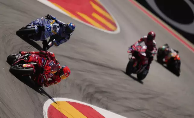 Spain's rider Marc Marquez of the Ducati Lenovo Team steers his motorcycle followed by Spain's rider Alex Marquez of the BK8 Gresini Racing MotoGP AND Italian rider Francesco Bagnaia of the Ducati Lenovo Team during the MotoGP race of the Grand Prix of Aragon at the MotorLand Aragon circuit, in Alcaniz, Spain, Sunday, June 8, 2025. (AP Photo/Jose Breton)