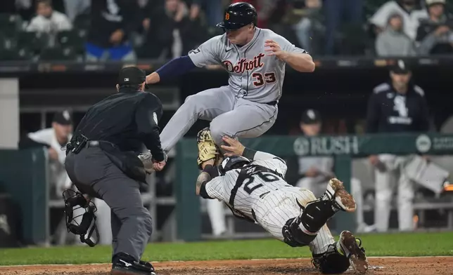 Detroit Tigers designated hitter Colt Keith (33) jumps over Chicago White Sox catcher Korey Lee (26) but is tagged out at home during the eighth inning of a baseball game Wednesday, June 4, 2025, in Chicago. (AP Photo/Erin Hooley)