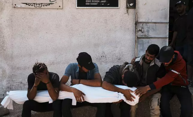 Palestinians mourn over the bodies of their relatives who were killed in an Israeli military strike on Gaza. at Al-Shifa Hospital in Gaza City, Wednesday, June 4, 2025. (AP Photo/Jehad Alshrafi)
