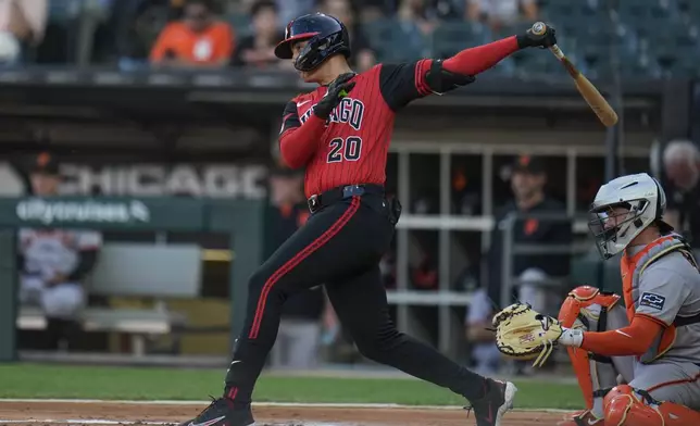 Chicago White Sox's Miguel Vargas (20) hits a one-run single during the first inning of a baseball game against the San Francisco Giants, Friday, June 27, 2025, in Chicago. (AP Photo/Erin Hooley)