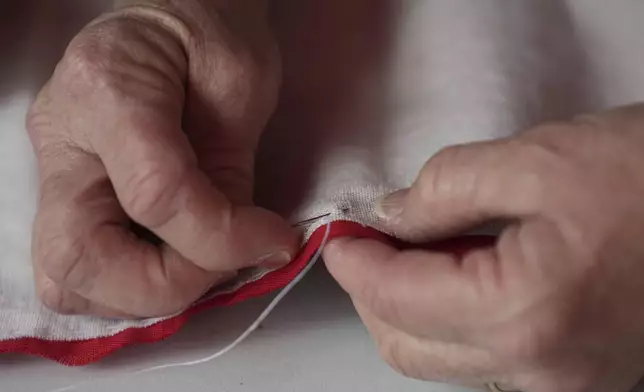 Cornelia Bridges demonstrates how a flag is stitched together at the Betsy Ross House in Philadelphia, Monday, June 9, 2025. (AP Photo/Matt Rourke)