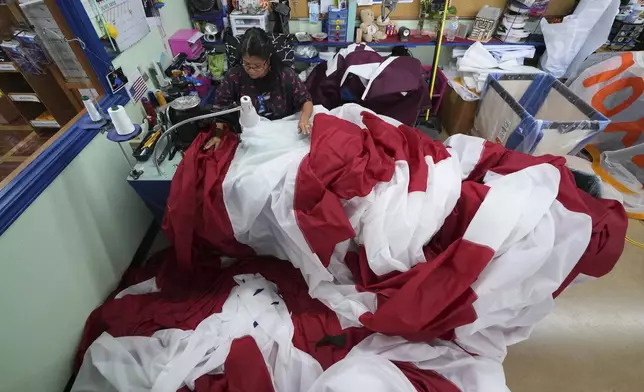 Lucy A. Rodriguez sews the stripes for a large U.S. flag at Dixie Flag and Banner, Tuesday, June 10, 2025, in San Antonio. (AP Photo/Eric Gay)