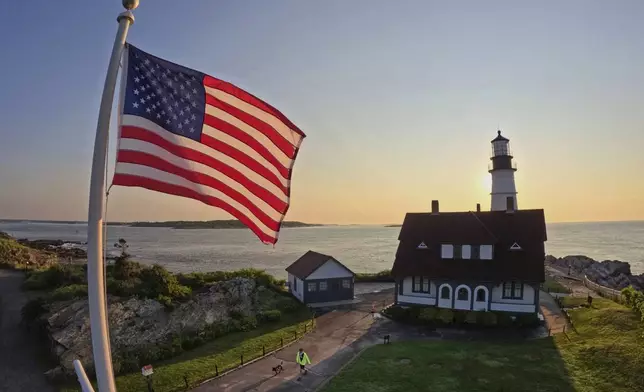 An American flag at Portland Head Light catches the light at sunrise, Wednesday, June 11, 2025, in Cape Elizabeth, Maine. (AP Photo/Robert F. Bukaty)