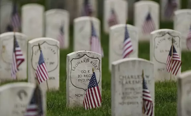 Old headstones at Leavenworth National Cemetery are marked with U.S. flags on the eve of Memorial Day, Sunday, May 25, 2025, in Leavenworth, Kan. (AP Photo/Charlie Riedel)