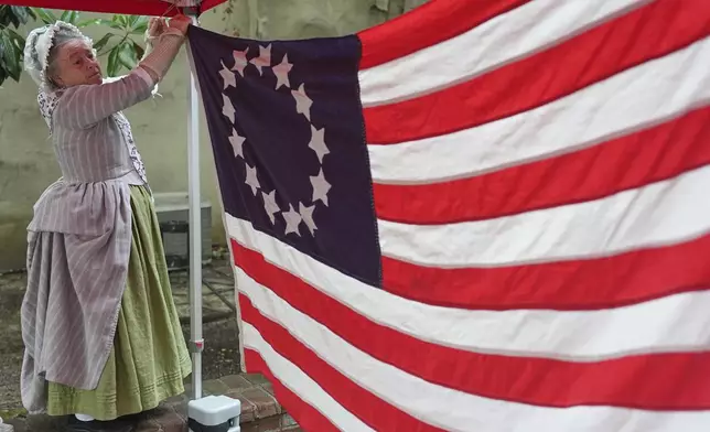Cornelia Bridges secures a flag for an education program at the Betsy Ross House in Philadelphia, Monday, June 9, 2025. (AP Photo/Matt Rourke)