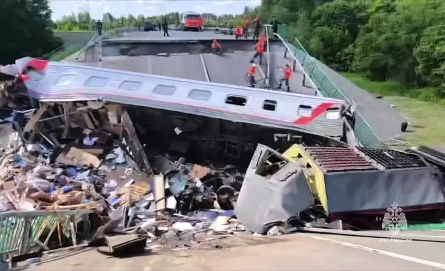 In this photo released by Russian Emergency Ministry Press Service telegram channel on Sunday, June 1, 2025, emergency employees work at a damaged bridge in Russia's Bryansk region, which borders Ukraine. (Russian Emergency Ministry Press Service telegram channel via AP)