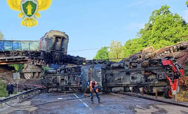 In this photo released by Moscow Interregional Transport Prosecutor's Office telegram channel on Sunday, June 1, 2025, an emergency employee works at a damaged bridge after the crash of a freight train in Russia's Kursk region, which borders Ukraine. (Moscow Interregional Transport Prosecutor's Office telegram channel via AP)