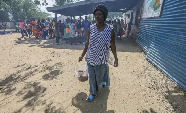 Aujene Cimanimpaye, from the Democratic Republic of Congo, brings lunch to her family at the Kakuma Refugee Camp in Turkana County, Kenya, Wednesday, June 4, 2025. (AP Photo/Andrew Kasuku)