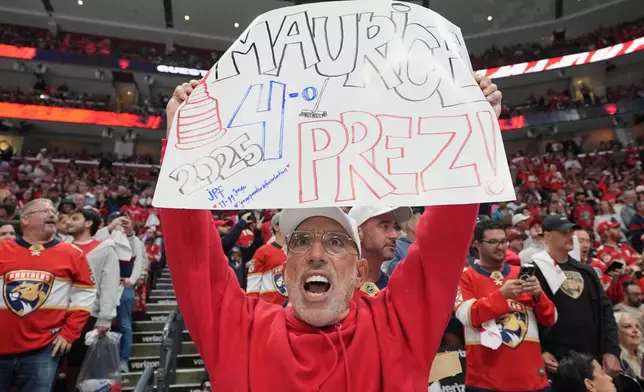 FILE - Florida Panthers fan Richard Ginsberg holds a sign during the first period in Game 4 of the NHL hockey Stanley Cup Eastern Conference finals against the Carolina Hurricanes, Monday, May 26, 2025, in Sunrise, Fla. (AP Photo/Lynne Sladky, File)