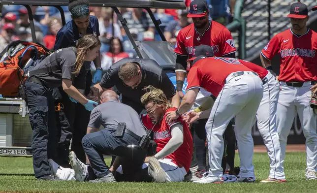 Cleveland Guardians' Gabriel Arias, sitting, is assisted after being injured during the third inning of a baseball game against the St. Louis Cardinals, Sunday, June 29, 2025, in Cleveland. (AP Photo/Phil Long)