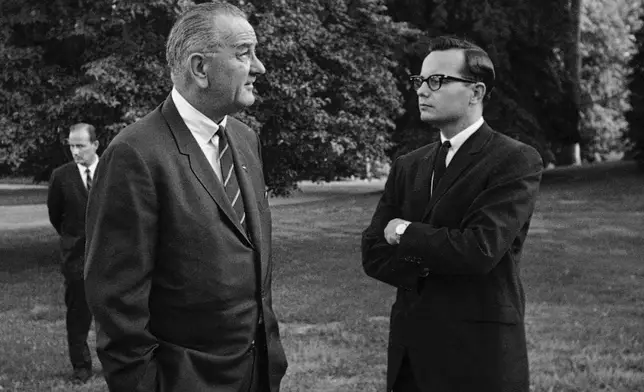 FILE - President Lyndon B. Johnson, right, talks with press secretary Bill Moyers on the South Lawn of the White House in Washington on Aug. 30, 1965. (AP Photo/William J. Smith, File)