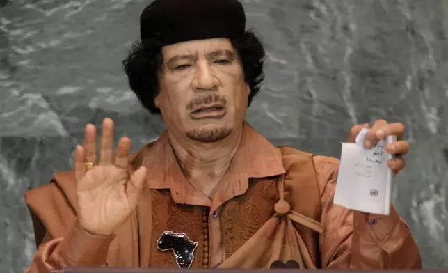 FILE - Libyan leader Moammar Gadhafi shows a torn copy of the UN Charter during his address to the 64th session of the United Nations General Assembly, Sept. 23, 2009. (AP Photo/Richard Drew, File)