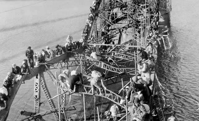 FILE - Residents from Pyongyang, North Korea, and refugees from other areas crawl over shattered girders of the city's bridge Dec. 4, 1950, as they flee south across the Taedong River to escape the advance of Chinese Communist troops. (AP Photo/Max Desfor, File)