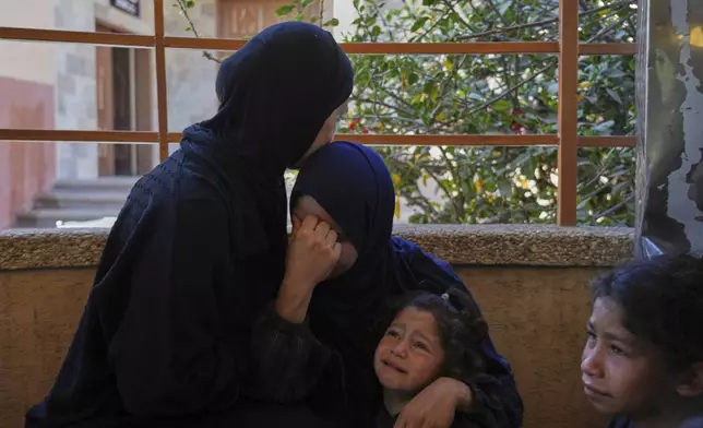 Sherin Wafi, center, and her daughter Mira, 4, mourn during the funeral of her husband Hosam Wafi who, according to family members, was killed during an Israeli strike, in Khan Younis, southern Gaza Strip, Monday, June 2, 2025. (AP Photo/Abdel Kareem Hana)