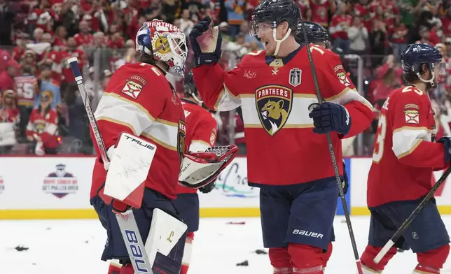 Florida Panthers defenseman Niko Mikkola (77) congratulates goaltender Sergei Bobrovsky (72) after defeating the Edmonton Oilers in Game 3 of the NHL Stanley Cup final Monday, June 9, 2025, in Sunrise, Fla. (AP Photo/Lynne Sladky)