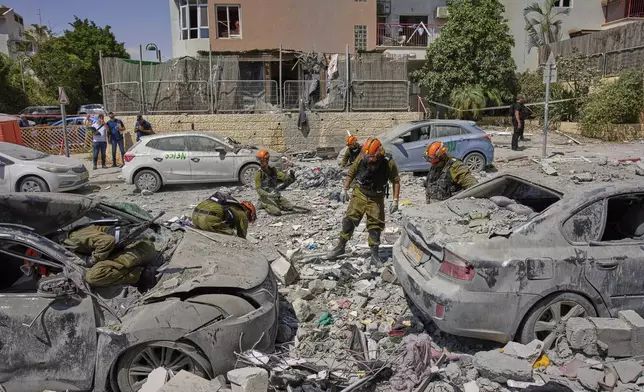 Israeli soldiers work amid the rubble of residential buildings destroyed by an Iranian missile strike that killed several people, in Beersheba, Israel, on Tuesday, June 24, 2025. (AP Photo/Bernat Armangue)