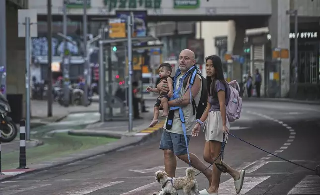 People leave an underground parking garage where they took shelter after an air raid alarm of Iranian missile attacks went off, in Tel Aviv, Israel, Tuesday, June 24, 2025. (AP Photo/Ohad Zwigenberg)