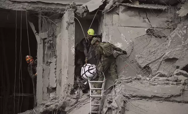 Israeli soldiers and rescue team work amid the rubble of residential buildings destroyed by an Iranian missile strike that killed several people, in Beersheba, Israel, on Tuesday, June 24, 2025. (AP Photo/Leo Correa)