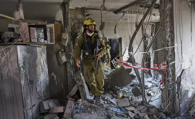Israeli soldiers from the search and rescue unit work amid the rubble of residential buildings destroyed by an Iranian missile strike that killed several people, in Beersheba, Israel, on Tuesday, June 24, 2025. (AP Photo/Bernat Armangue)