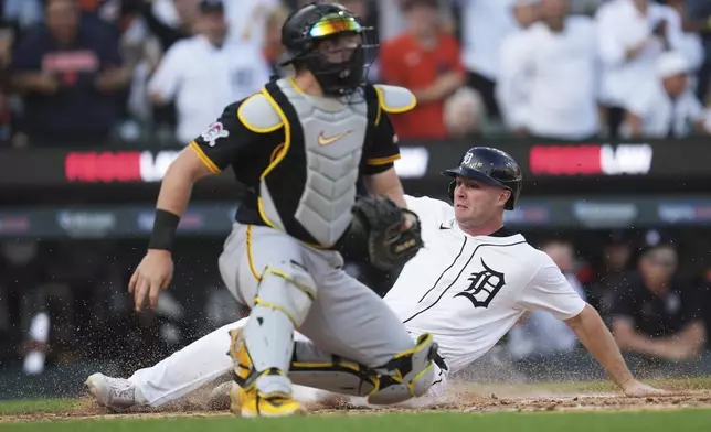 Detroit Tigers' Colt Keith slides safely into home plate ahead of the tag by Pittsburgh Pirates catcher Henry Davis in the fifth inning during the second baseball game of a doubleheader, Thursday, June 19, 2025, in Detroit. (AP Photo/Paul Sancya)