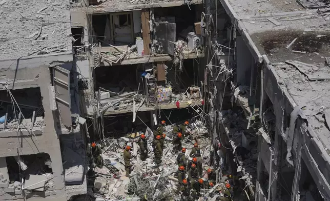 Israeli soldiers dig through rubble to search for survivors in a residential area hit by a missile fired from Iran, in Bat Yam, central Israel, Sunday, June 15, 2025.(AP Photo/Ariel Schalit)