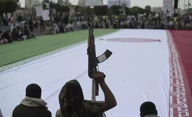 Houthi supporters surround a giant Iranian flag during an anti-U.S. and anti-Israel weekly rally in Sanaa, Yemen, Friday, June 20, 2025. (AP Photo/Osamah Abdulrahman)