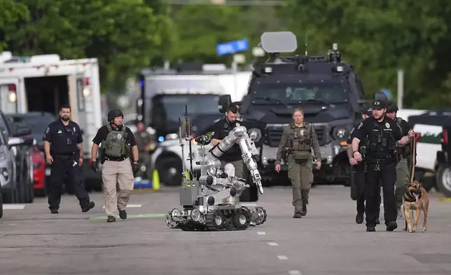 Law enforcement officials investigate after an attack on the Pearl Street Mall Sunday, June 1, 2025, in Boulder, Colo. (AP Photo/David Zalubowski)