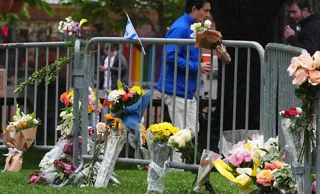 Bouquets of flowers stand along a makeshift memorial for victims of an attack outside of the Boulder County, Colo., courthouse as a light rain falls Tuesday, June 3, 2025, in Boulder, Colo. (AP Photo/David Zalubowski)