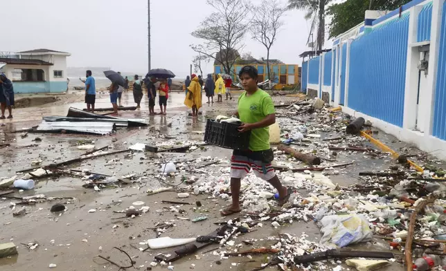 A walks through debris after Hurricane Erick hit near Puerto Escondido, Oaxaca state, Mexico, Thursday, June 19, 2025. (AP Photo/Luis Alberto Cruz)