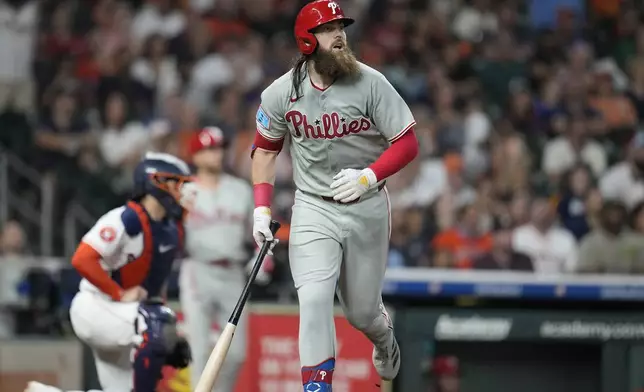 Philadelphia Phillies' Brandon Marsh watches his sacrifice fly score a run to tie a baseball game against the Houston Astros during the eighth inning Thursday, June 26, 2025, in Houston. (AP Photo/Karen Warren)