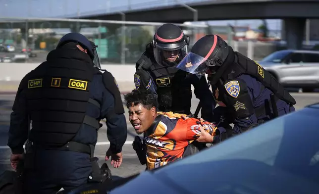 A protester is arrested by California Highway Patrol near the federal building in downtown Los Angeles on Tuesday, June 10, 2025. (AP Photo/Eric Thayer)