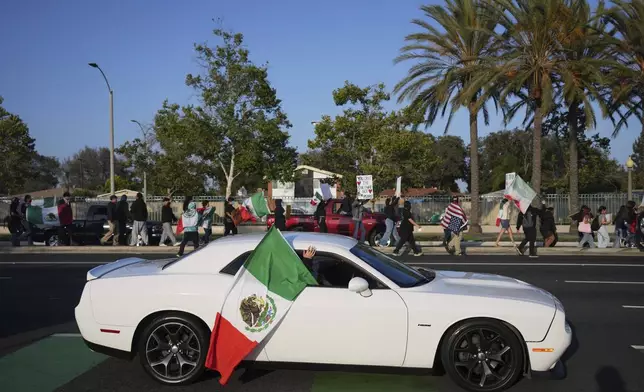 Protesters march along a street Tuesday, June 10, 2025, in Santa Ana, Calif. (AP Photo/Jae C. Hong)