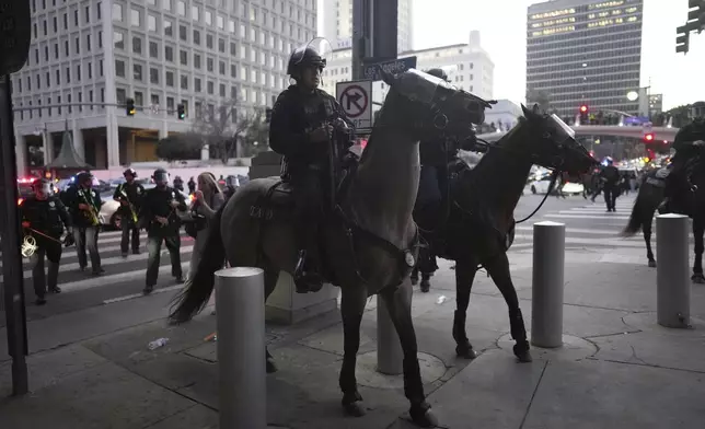 Los Angeles Police Department officers on horseback move through a street during a protest on Tuesday, June 10, 2025, in Los Angeles. (AP Photo/Eric Thayer)