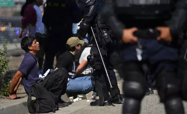 Protesters are detained by law enforcement near the federal building in downtown Los Angeles on Tuesday, June 10, 2025. (AP Photo/Eric Thayer)