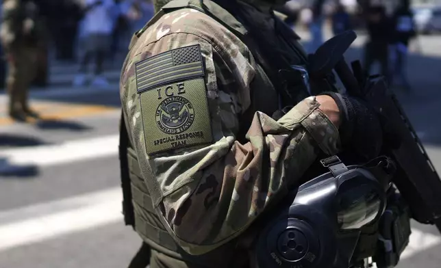 An ICE Special Response Team member stands guard outside the Metropolitan Detention Center, while protesters gathered outside to denounce ICE operations, Tuesday, June 10, 2025, in downtown Los Angeles. (AP Photo/Eric Thayer)