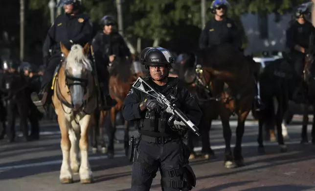 A Los Angeles Metro police officer stands guard during a protest on Wednesday, June 11, 2025, in Los Angeles. (AP Photo/Ethan Swope)