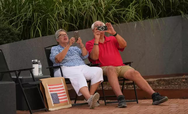 Visitors record by their phones as anti ICE protesters march in downtown San Antonio, Wednesday, June 11, 2025. (AP Photo/Eric Gay)