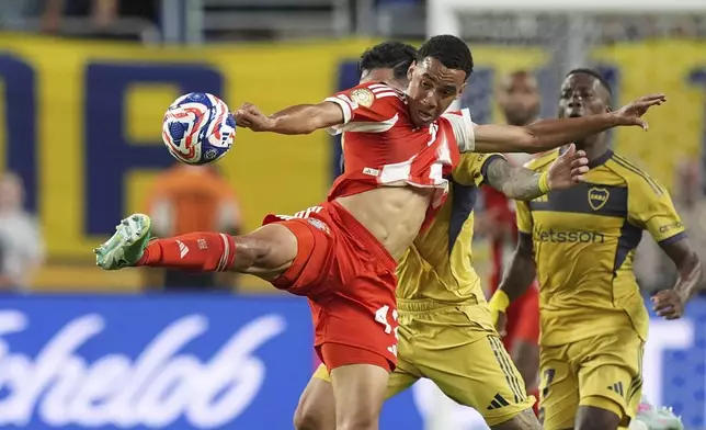 Bayern Munich's Jamal Musiala, front, is challenged by Boca Juniors' Lautaro Di Lollo, back, during the Club World Cup Group C soccer match between Bayern Munich and Boca Juniors in Miami Gardens, Fla., Friday, June 20, 2025. (AP Photo/Rebecca Blackwell)