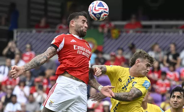 Benfica's Nicolas Otamendi, left, heads the ball as Auckland City's Adam Mitchell defends during the Club World Cup Group C soccer match between Benfica and Auckland City in Orlando, Fla., Friday, June 20, 2025. (AP Photo/Phelan Ebenhack)