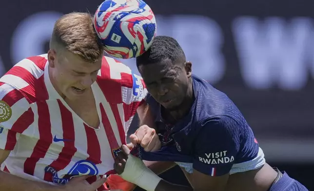 Atletico Madrid's Alexander Sorloth, left, goes for a header with Paris Saint-Germain's Willian Pacho during the Club World Cup group B soccer match between PSG and Atletico Madrid, in Pasadena, Calif., Sunday, June 15, 2025. (AP Photo/Mark J. Terrill)