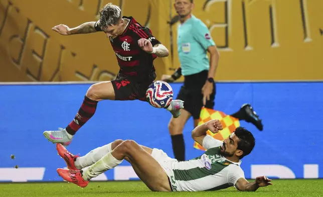 Esperance de Tunis' Mohamed Amine Ben Hamida competes for the ball with Flamengo's Guillermo Varela, top, during the Club World Cup group D soccer match between Flamengo and ES Tunisie, in Philadelphia, Monday, June 16, 2025. (AP Photo/Derik Hamilton)