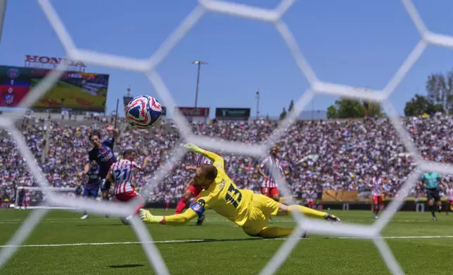 Atletico Madrid's goalkeeper Jan Oblak, foreground, fails to block a shot by Paris Saint-Germain's Vitinha, background left, to score his side's second goal during the Club World Cup group B soccer match between PSG and Atletico Madrid, in Pasadena, Calif., Sunday, June 15, 2025. (AP Photo/Mark J. Terrill)