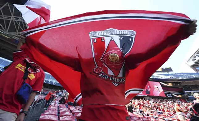A Urawa supporter holds up a flag before the Club World Cup group E soccer match between River Plate and Urawa Red Diamonds in Seattle, Tuesday, June 17, 2025. (AP Photo/Ryan Sun)