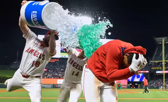 Los Angeles Angels' Nolan Schanuel (18) and Angels' catcher Logan O'Hoppe dump coolers of liquid on Angels' Christian Moore (4) as they celebrate his walk-off two-run home run in the tenth inning of a baseball game against the Boston Red Sox, Tuesday, June 24, 2025, in Anaheim, Calif. (AP Photo/Jayne Kamin-Oncea)