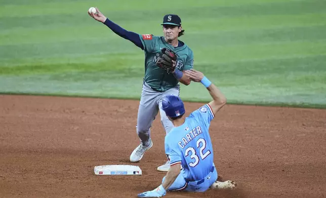 Seattle Mariners second baseman Cole Young throws to first to complete the double play after forcing Texas Rangers' Evan Carter (32) at second in the fourth inning of a baseball game, Sunday, June 29, 2025, in Arlington, Texas. (AP Photo/Tony Gutierrez)