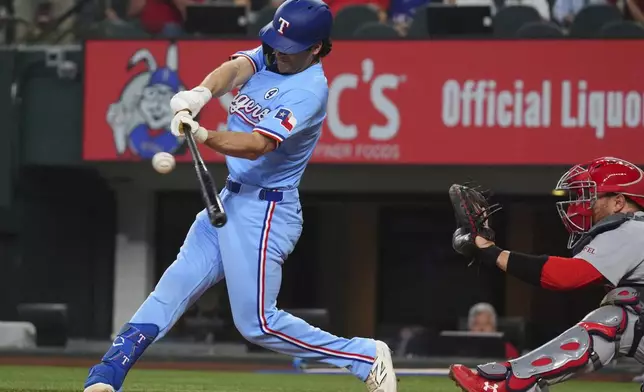 Texas Rangers' Josh Smith, left, hits a double that scored teammates Marcus Semien and Sam Haggerty in front of St. Louis Cardinals catcher Pedro Pagés during the second inning of a baseball game, Sunday, June 1, 2025, in Arlington, Texas. (AP Photo/LM Otero)