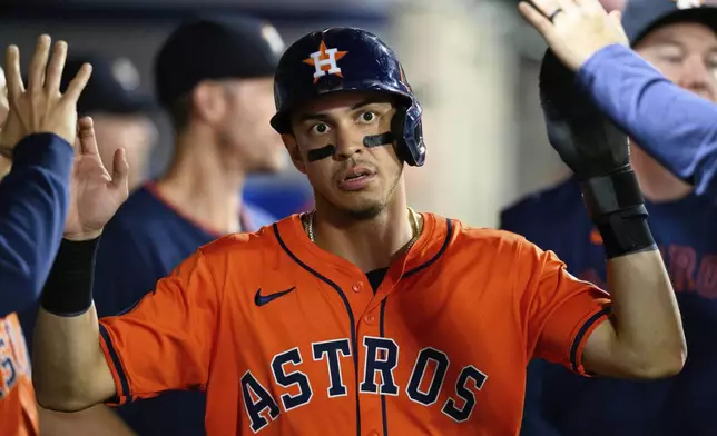 Houston Astros' Mauricio Dubón celebrates with teammates after scoring on a wild pitch during the 10th inning of a baseball game against the Los Angeles Angels, Friday, June 20, 2025, in Anaheim, Calif. (AP Photo/William Liang)